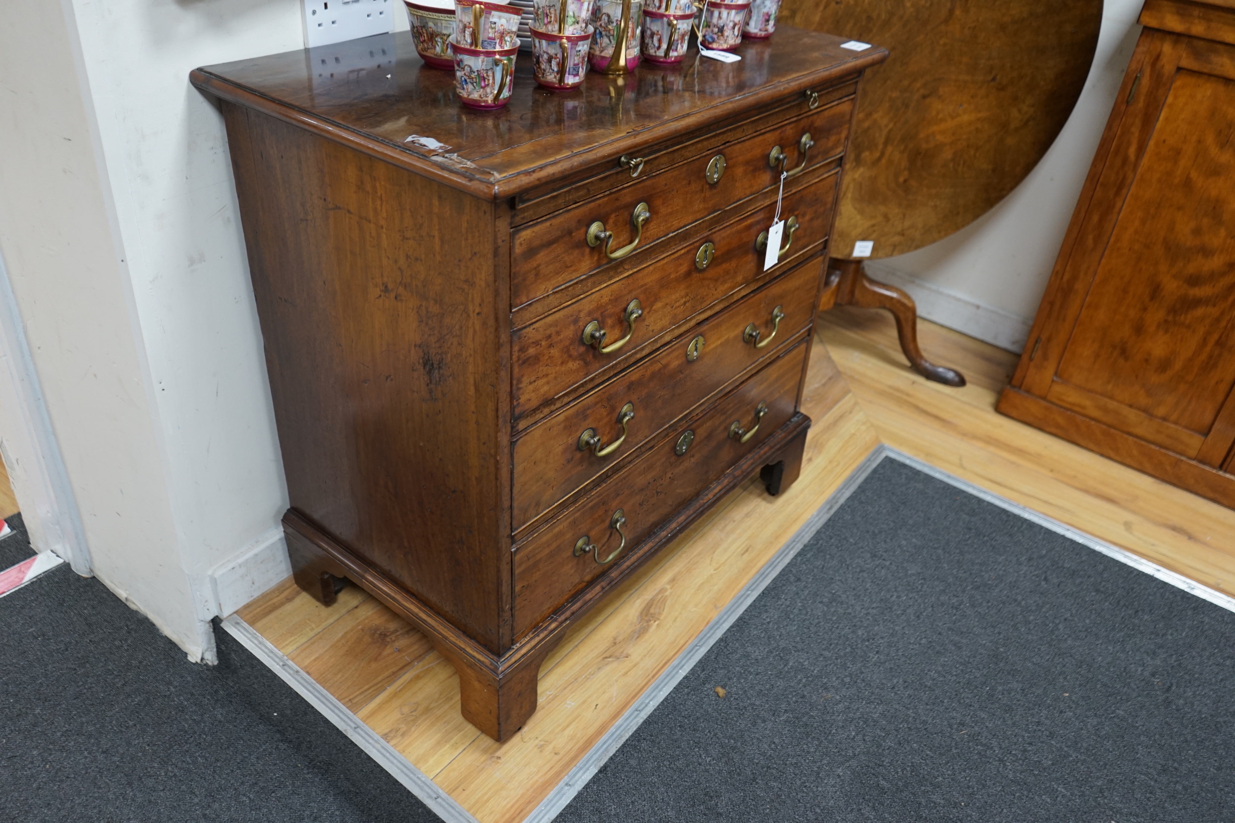 A George III mahogany chest of four graduating long drawers with brushing slide and brass handles, width 85cm depth 49cm height 84cm